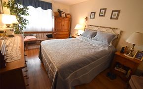 Dover apartment for rent - A bedroom with a bed, nightstand, and a window with curtains.
