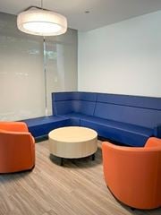 Chicago apartment for rent - A modern meeting room with a blue backdrop and orange chairs.