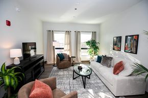 Chicago apartment for rent - A living room with a white couch, a brown armchair, and a coffee table.