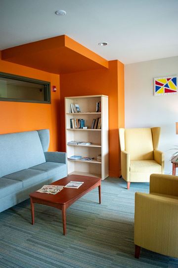 Chicago apartment for rent - A living room with a grey sofa, a yellow chair, a bookshelf and a coffee table.