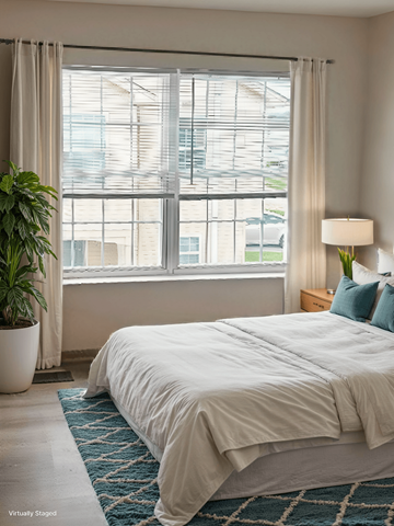 Blacklick apartment for rent - A bedroom with a large bed and a potted plant.