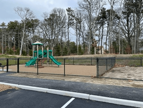 Brewster apartment for rent - A playground with a green slide and a black fence.