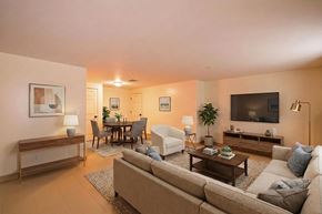 Florence townhouse for rent - A living room with a couch, a chair, a dining table, and a television.
