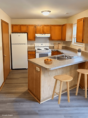 Blacklick apartment for rent - A kitchen with a white fridge and wooden cabinets.