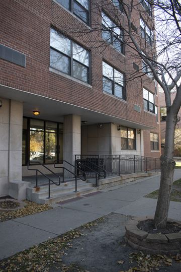 Chicago apartment for rent - a brick building with stairs and a tree in front of it