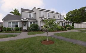 East Sandwich townhouse for rent - A grey house with a tree in front of it.