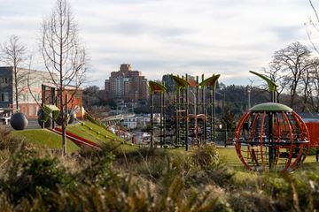 Seattle apartment for rent - A playground with a red and black spherical structure in the foreground.