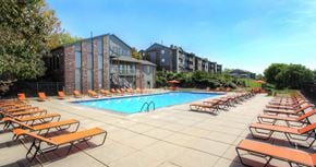Omaha apartment for rent - Huge swimming pool with spacious sundeck, poolside lounge chairs, beautiful landscaping, and scenic views at LionsHead Apartments in Omaha, Nebraska