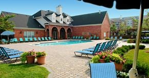 Lincoln apartment for rent - Luxury apartments with swimming pool, poolside lounge chairs, picnic area, grilling station, lush landscaping, and scenic views at Lenox Village Apartments in Lincoln, Nebraska