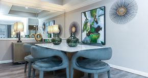 Dallas apartment for rent - Dining room with mirror accent wall, recessed ceiling, wood plank floors, gray colored walls at The Dorchester Apartments in Dallas Texas