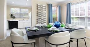Urbandale apartment for rent - Spacious dining room with oversized windows, u-shaped kitchen with white cabinets, and side-by-side refrigerator at Saddlebrook apartments in Urbandale Iowa