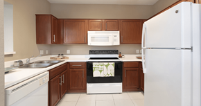Omaha apartment for rent - Spacious u-shaped kitchen with lots of cabinet space, lots of counter space, porcelain tile floor, and rich brown toned cabinets at The Biltmore Apartments in Omaha, Nebraska