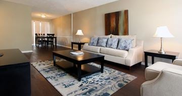 Houston apartment for rent - A living room with a white couch, a coffee table, and a painting on the wall.