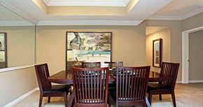 Houston apartment for rent - Spacious dining room area with mirror accent wall and kitchen with breakfast bar at Tuscany Lane Apartments in Houston.