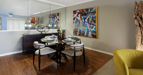 Dallas apartment for rent - Luxury apartments with spacious dining room, wood plank floors, breakfast bar, mirror accent wall, and 9-foot ceilings at Kensington Square Apartments.