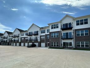Lincoln apartment for rent - A black car is parked in a parking lot in front of a white building.