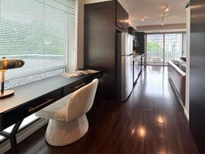 Minneapolis apartment for rent - A modern kitchen with dark wood floors and a black refrigerator.