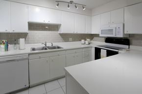 Omaha apartment for rent - A kitchen with white cabinets and a white counter.