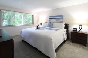 Omaha apartment for rent - A bedroom with a large bed and a painting on the wall.