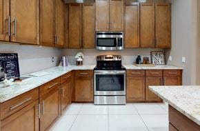 Bloomington apartment for rent - Luxury apartments in Bloomington Minnesota with spacious kitchen, granite countertops, stainless steel appliances, built-in wine rack, kitchen island, and porcelain tile floor at Luxembourg Apartments