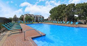 Omaha apartment for rent - Huge swimming pool with spacious sundeck, poolside lounge chairs, beautiful landscaping, and scenic views at The Vanderbilt Apartments in Omaha, Nebraska