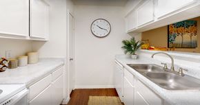 Houston apartment for rent - Bright white kitchens with wood plank floors at Waters of Winrock Apartments in Houston