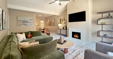 Houston apartment for rent - A living room with a green couch and a fireplace.