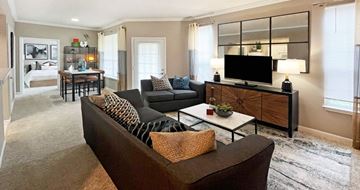 Omaha apartment for rent - A living room with a brown couch and a wooden cabinet.