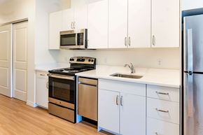 Wyandanch apartment for rent - A kitchen with white cabinets and a black stove top oven.