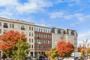 Wyandanch apartment for rent - A row of buildings with autumn trees in front.