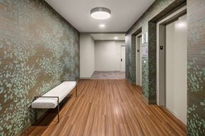 Wyandanch apartment for rent - A long hallway with a bench and doors on the right.