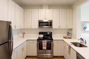 Wyandanch apartment for rent - A kitchen with white cabinets and a stainless steel refrigerator.