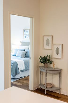 Wyandanch apartment for rent - A bedroom with a bed and a table with a plant on it.