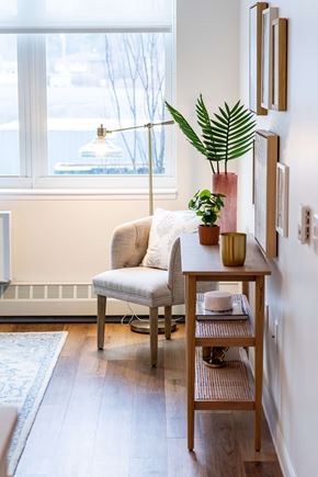 Wyandanch apartment for rent - A living room with a chair, a table, and a plant.