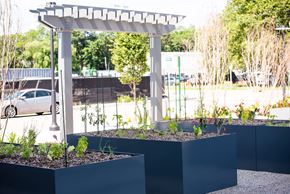 Wyandanch apartment for rent - A white pergola stands over a garden with two planters.