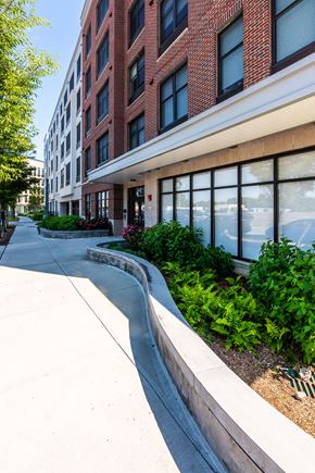 Wyandanch apartment for rent - A red brick building with a white trim and a landscaped area in front.