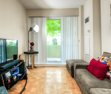 Toronto apartment for rent - A living room with a grey couch and a television.