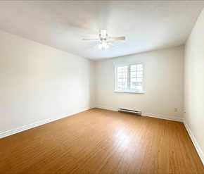 Moncton apartment for rent - A room with a ceiling fan and a window.