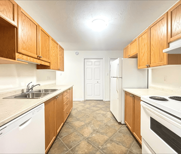 Moncton apartment for rent - A kitchen with wooden cabinets and white appliances.