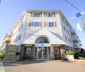 Moncton apartment for rent - A large white building with a sign that says "Residence" in front of it.