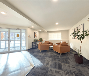 Moncton apartment for rent - A spacious waiting room with a grey carpet and orange chairs.