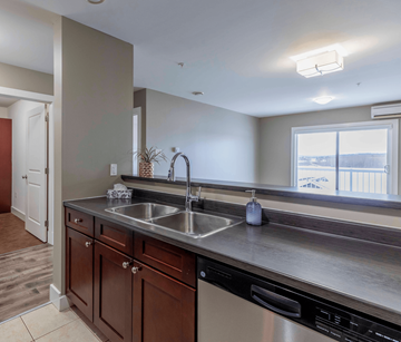 Fredericton apartment for rent - A kitchen with a stainless steel sink and brown cabinets.