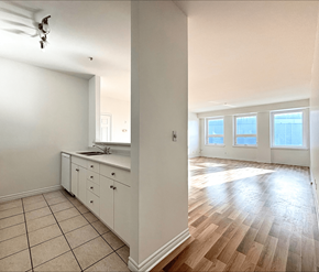 Moncton apartment for rent - A kitchen with white cabinets and a wooden floor.