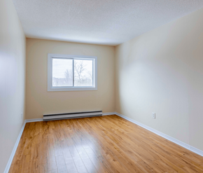 Fredericton apartment for rent - Empty room with a window and wooden floor.