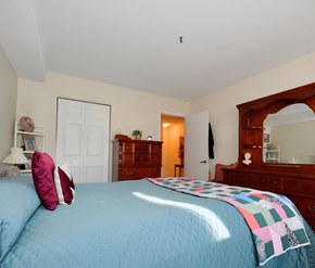 Halifax apartment for rent - A bedroom with a blue bedspread and a wooden dresser.