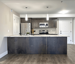 Dieppe apartment for rent - A modern kitchen with a dark island and stainless steel appliances.