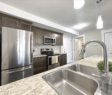 Dieppe apartment for rent - A kitchen with a stainless steel sink and refrigerator.