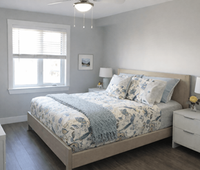 Fredericton apartment for rent - A bedroom with a large bed and a ceiling fan.