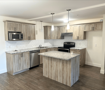 Fredericton apartment for rent - A kitchen with wooden cabinets and a granite countertop.