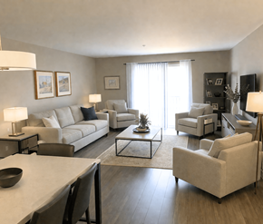 Fredericton apartment for rent - A living room with a white couch, a coffee table, and a television.